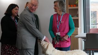 King Charles III meeting Agnus a therapy dog whilst opening the Priscilla Bacon Lodge hospice, a state-of-the-art palliative care unit which has been specially designed to allow patients to enjoy the surrounding landscape, working in partnership with Norfolk Community Health and Care NHS Trust on October 26, 2023 in Norwich, England.
