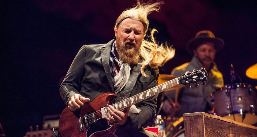 Derek Trucks wears a gray blazer as he takes a solo at Red Rocks, Colorado, in 2015. A couple of months later he would be revisiting the Mad Dogs tour of 1970 with Leon Russell as Tedeschi Trucks Band headlined LOCKN&#039; Festival with a historic set and reunion of the Joe Cocker and Russell-led band.