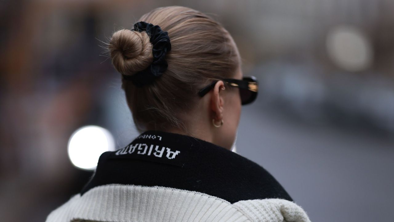 Low-maintenance hairstyles: woman wearing hair in a slicked-back bun street style