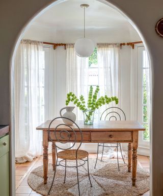 breakfast nook with farmhouse table paired with sculptural swirly iron chairs