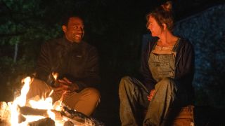 Chiwetel Ejiofor sits smiling with Renee Zellweger around a campfire in Bridget Jones: Mad About The Boy.