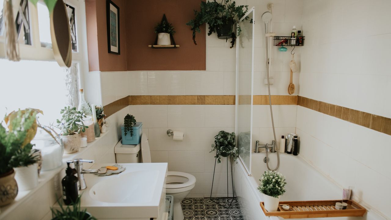 a terracotta-colored boho bathroom with lots of plants