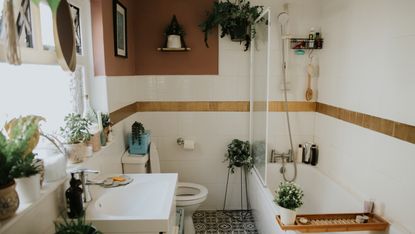 a terracotta-colored boho bathroom with lots of plants