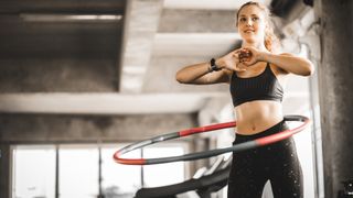 Woman using a weighted hula hoop during workout