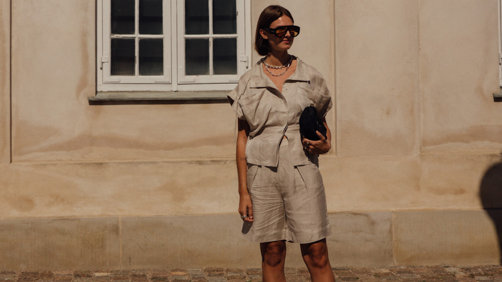 Copenhagen spring 2025 attendee wearing beige linen top and shorts with sunglasses