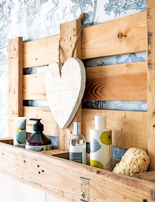 Upcycled wooden pallet bathroom shelf on floral patterned wall