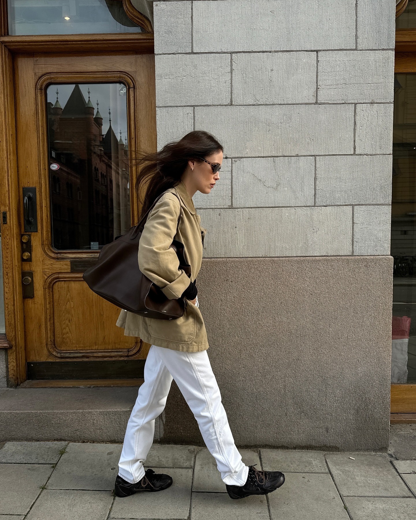 @annabelrosendahl wearing white jeans and dark sneakers.