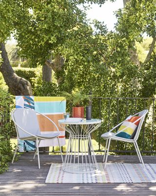 john lewis outdoor seating set with white chairs and bright accessories