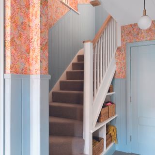 Staircase with blue wall panelling half height on wall.