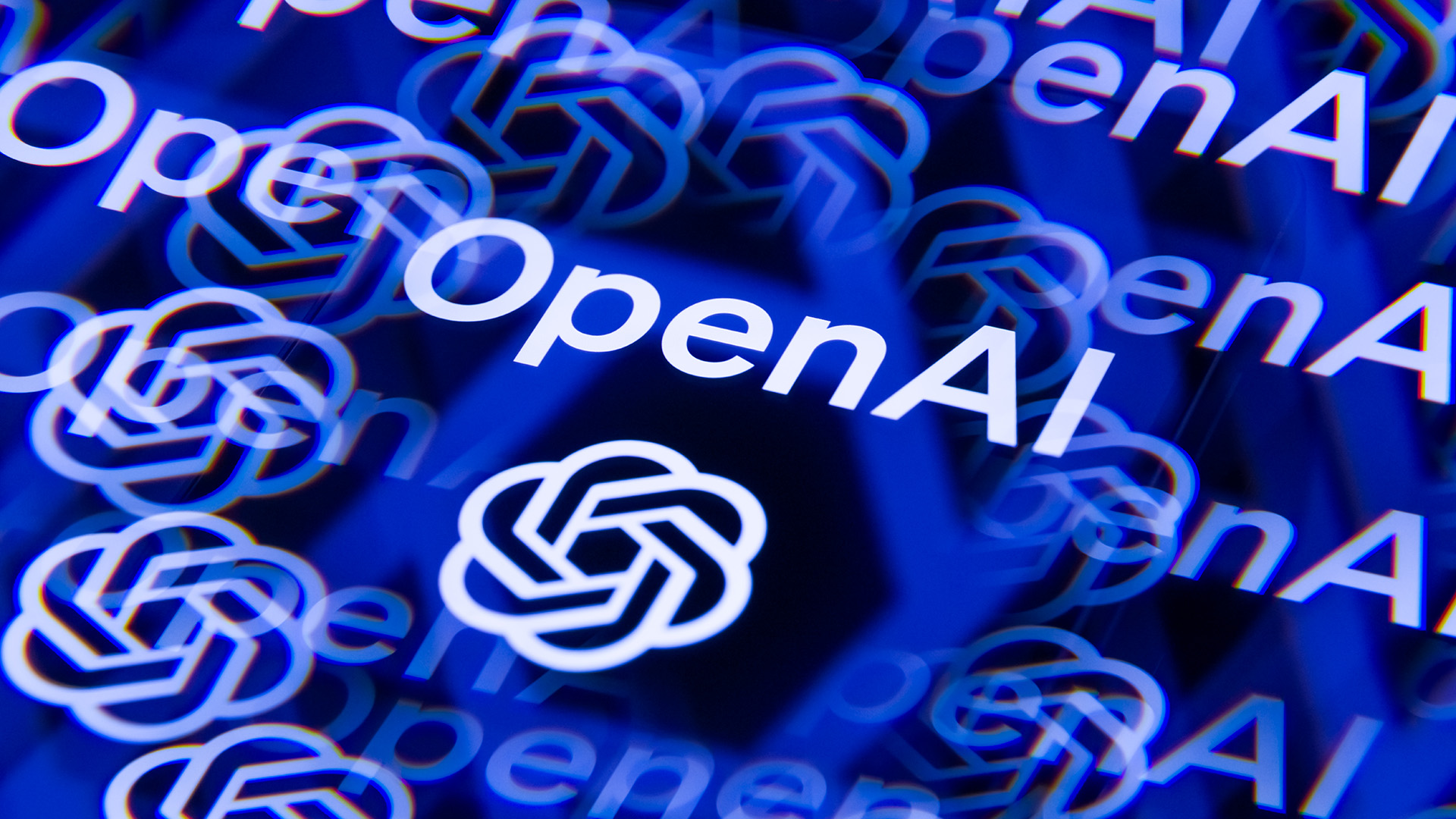 The OpenAI logo in white, reflected in a kaleidoscopic fashion on a blue background.