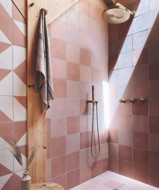 shower room with pink tiles and gold shower head