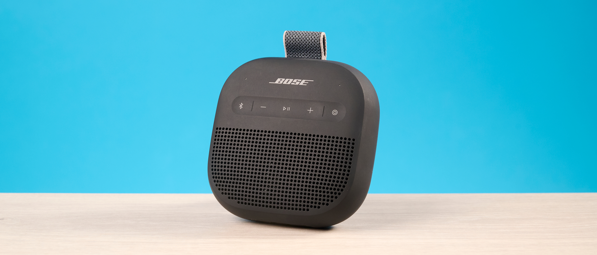 Bose SoundLink Micro 2 in black photographed in front of a blue background