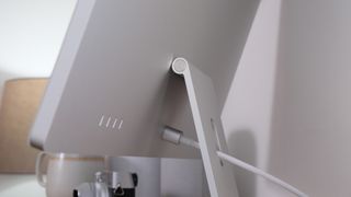 Close-up of the power connector on an Apple iMac on a wooden desk