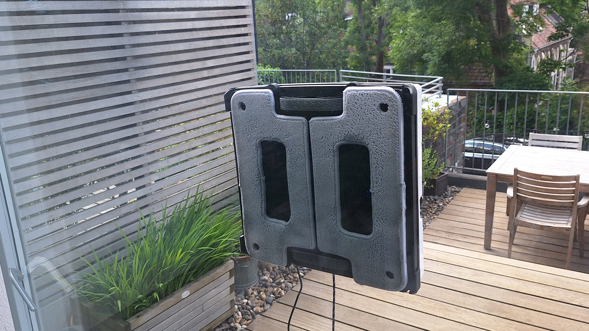 Hobot S7 Pro window cleaning robot on outside of reviewer's window, photographed from inside