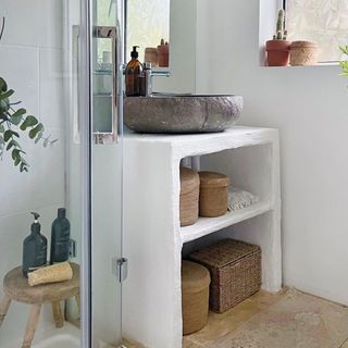 Gorgeous rustic and bright bathroom with open shelving vanity unit in white clay finish, and generous stone sink