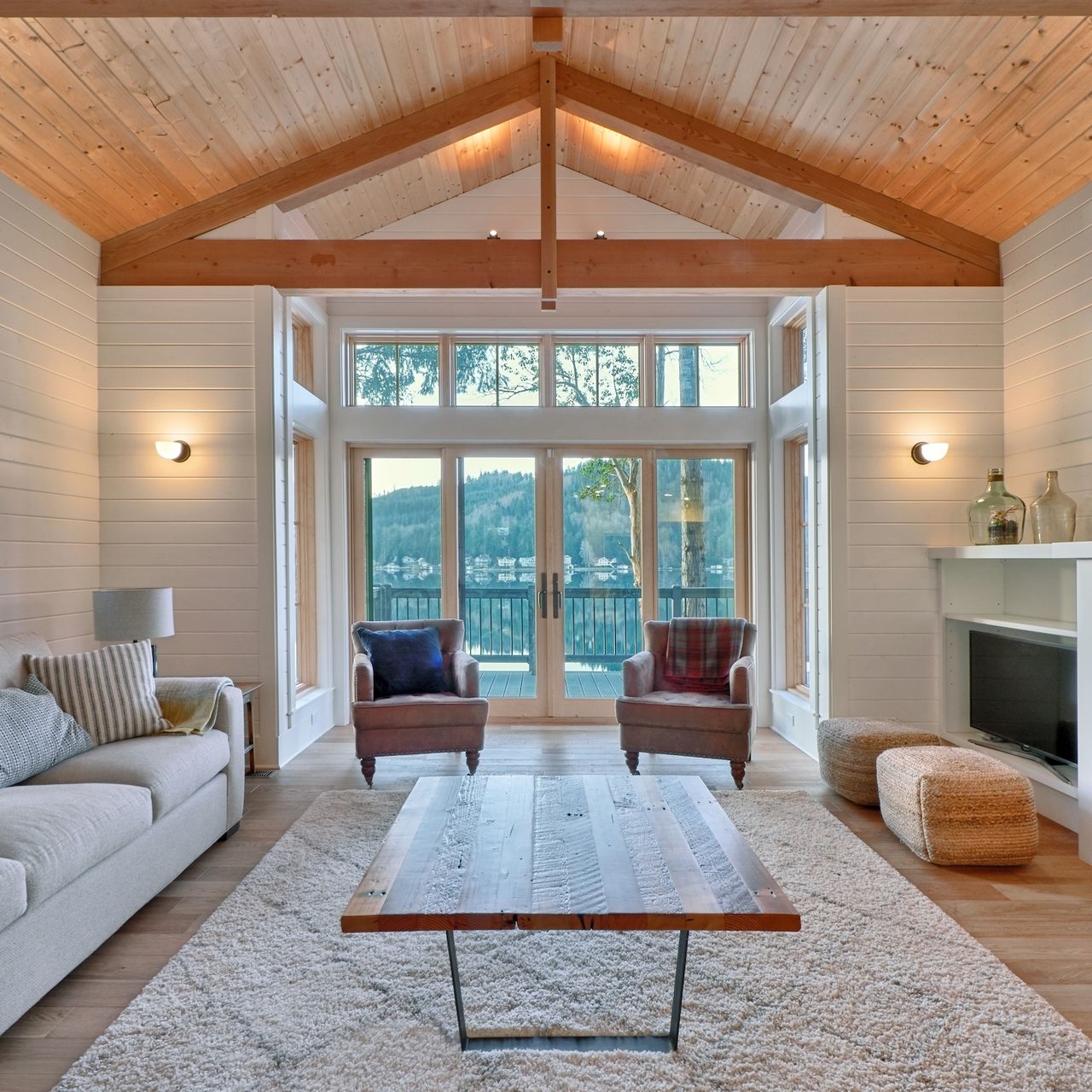 A living room with glass doors leading onto lakeside decking