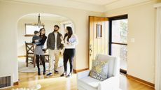 A couple with a small child look at a home for sale with a real estate agent.