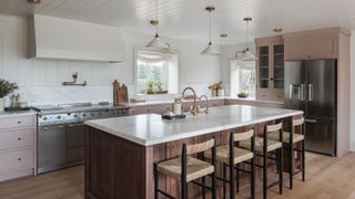 pink kitchen with island and stainless steel fridge