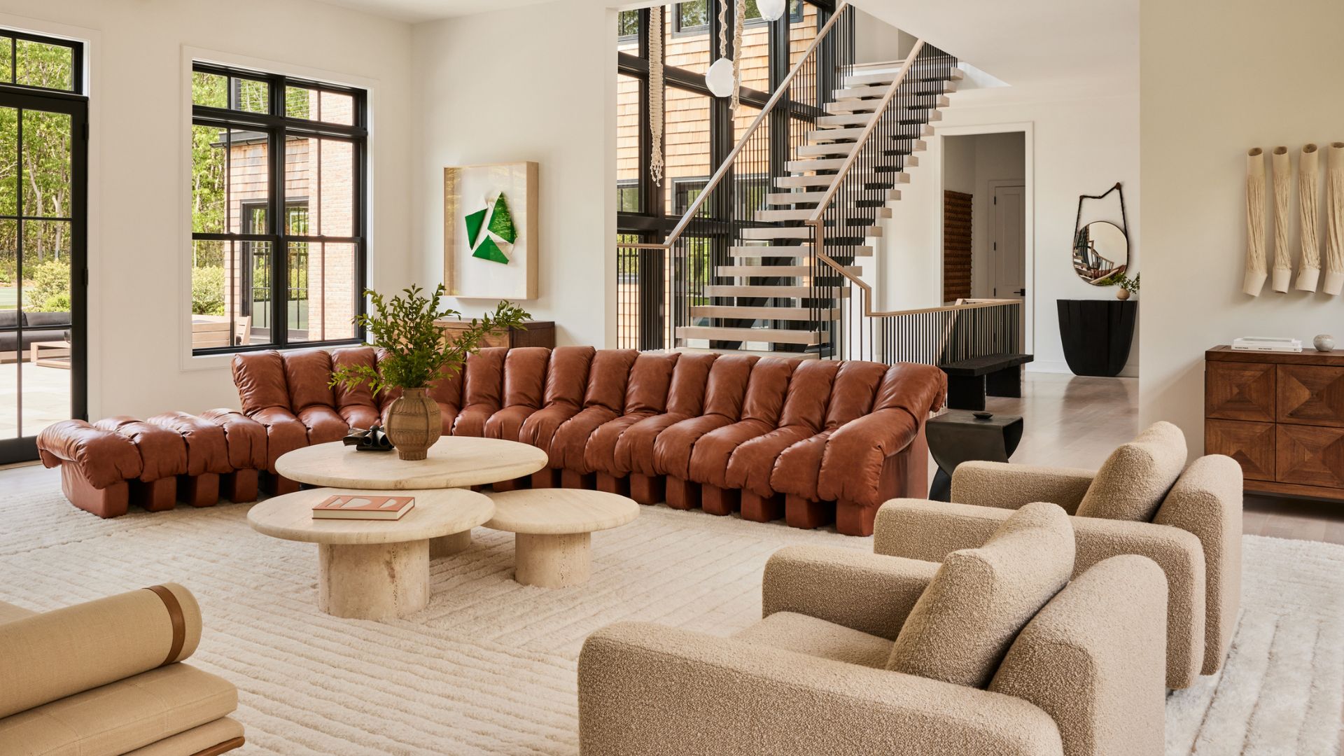 A living room with a front entryway and a staircase winding up