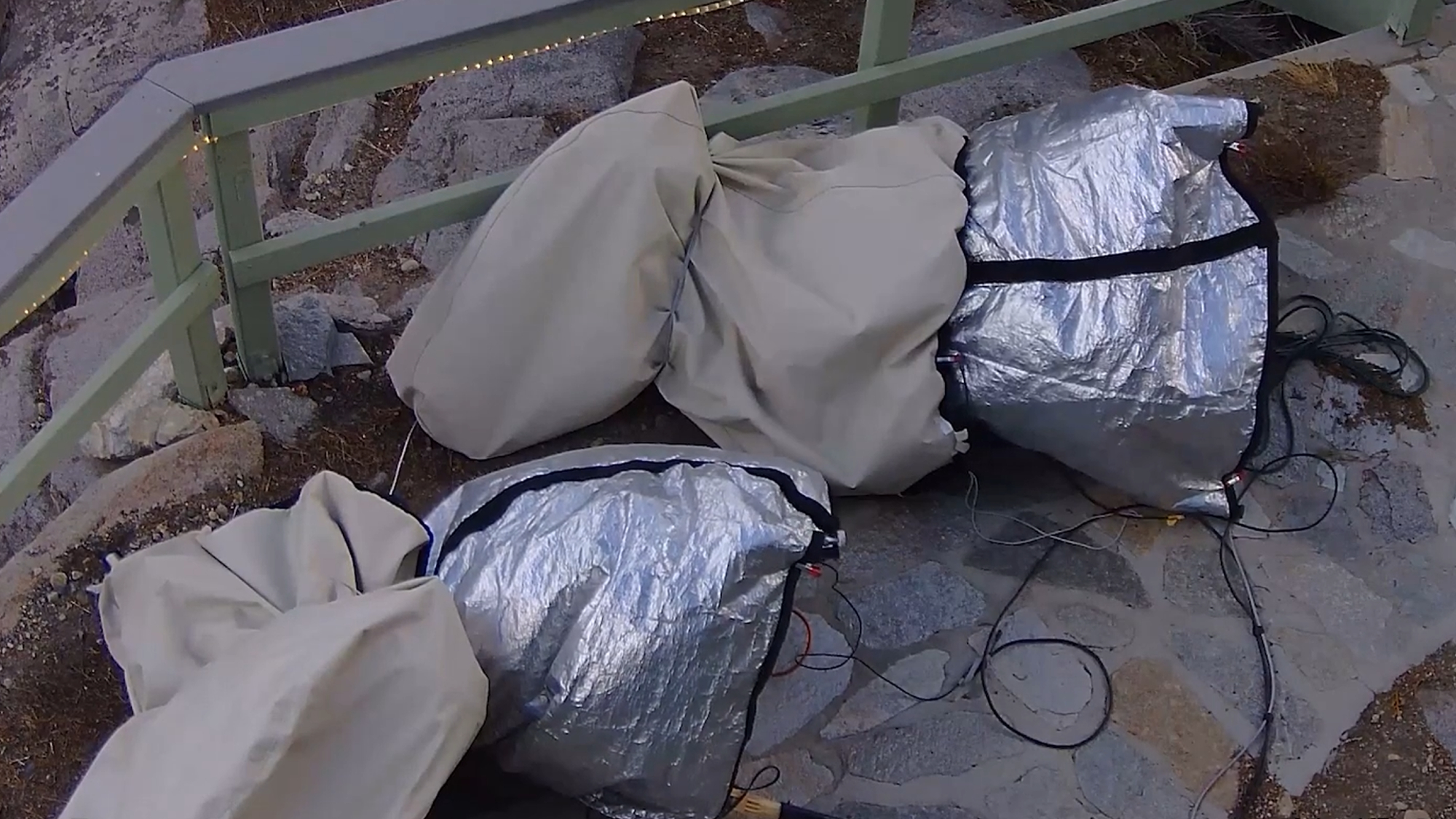 Two telescopes are pictured lying on the ground in covers having been blown over by high winds.