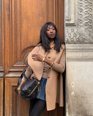 French Outfit Updates: @emmanuellek_ wears a camel coat with stacked gold bangles