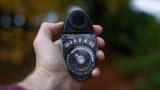 Sekonic Studio Deluxe III L-398A held in palm of hand, autumnal backdrop