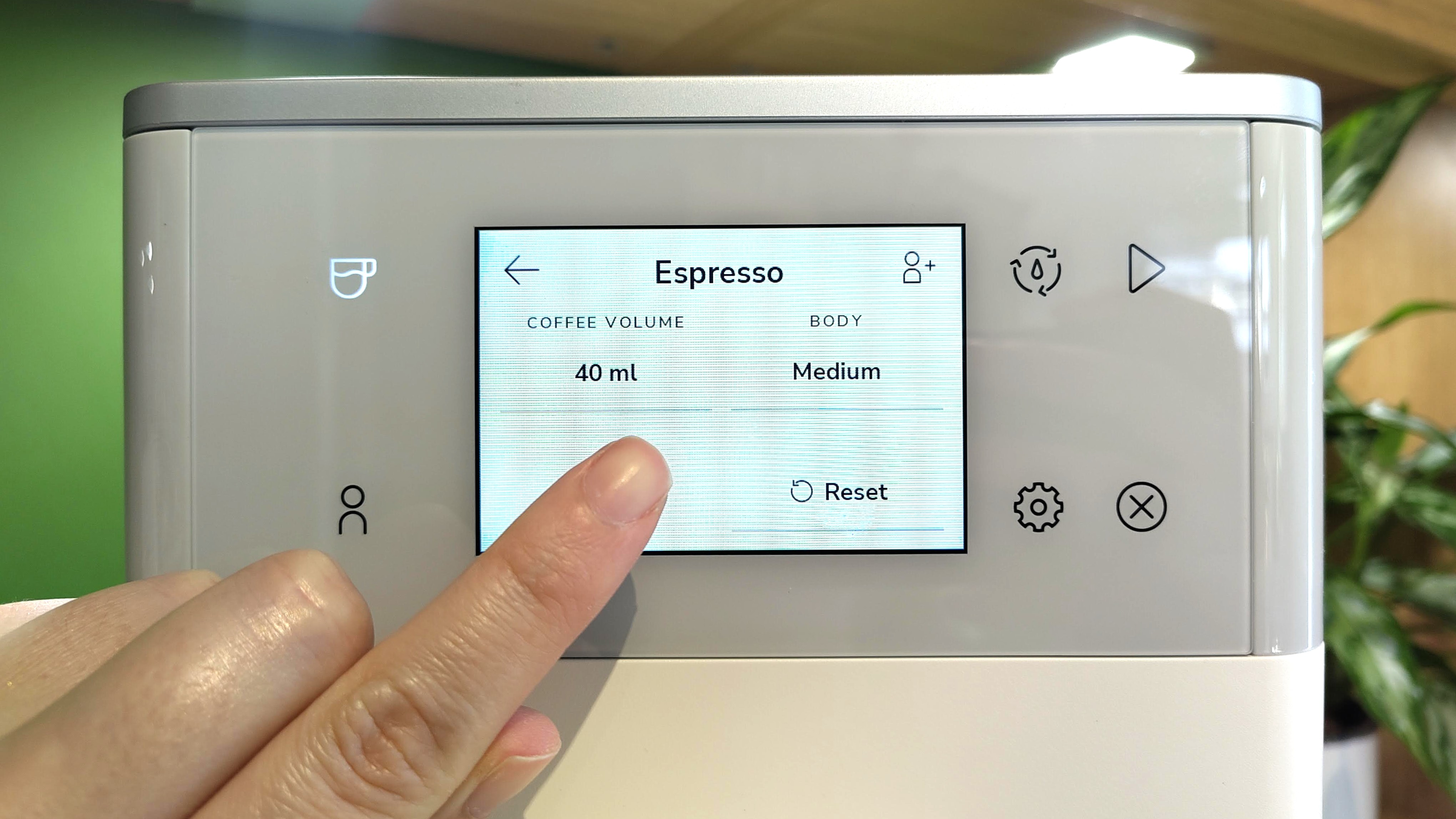 Person adjusting drink settings using KitchenAid KF4 espresso machine