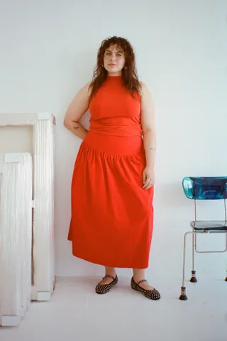 model wears red skirt and red top with mary janes