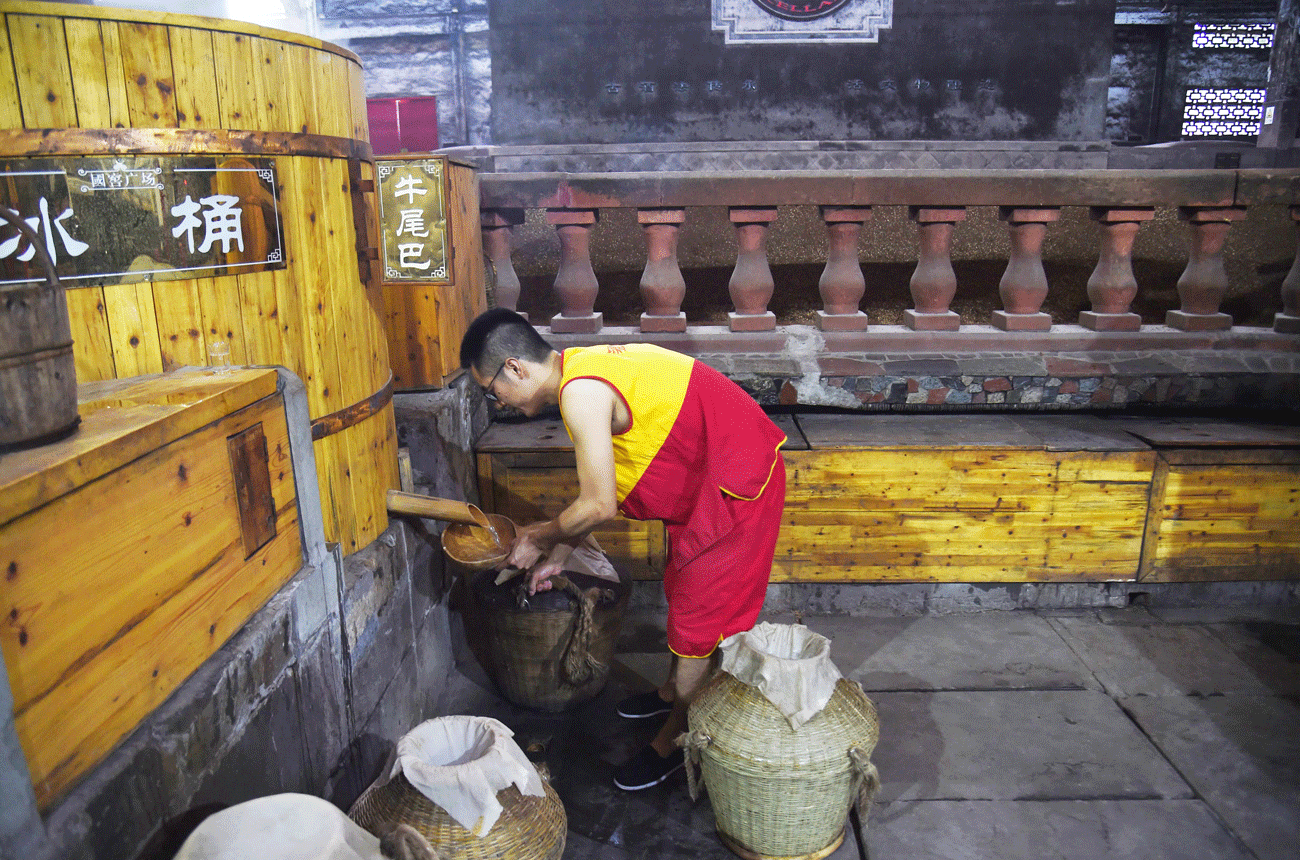 A worker collects distilled baijiu at the Luzhou Laojiao distillery in Sichuan province