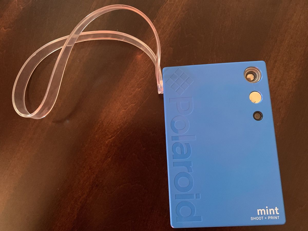 Blue Polaroid Mint Camera &amp; Printer laying on wooden table