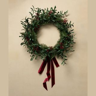 Christmas wreath with red berries and red velvet ribbon