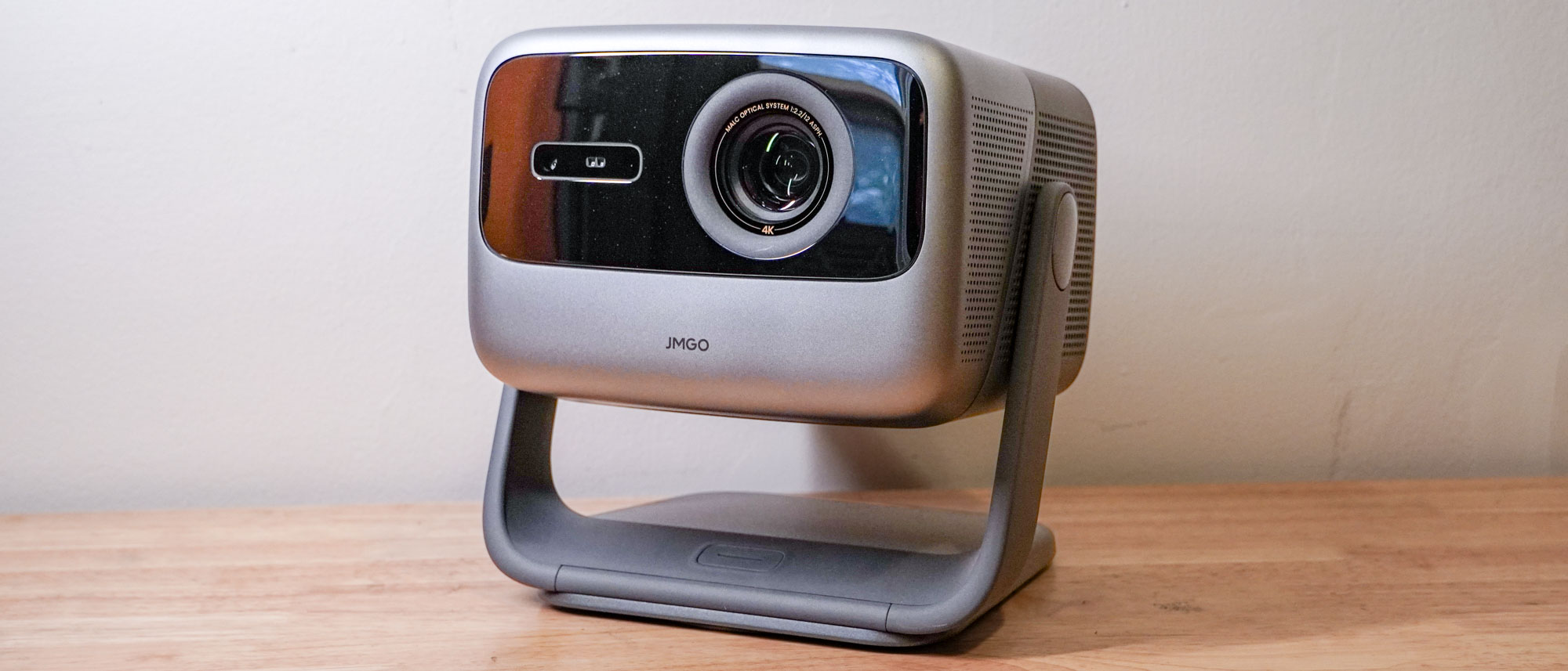 A JMGO N1S Ultimate projector on a wooden table top.