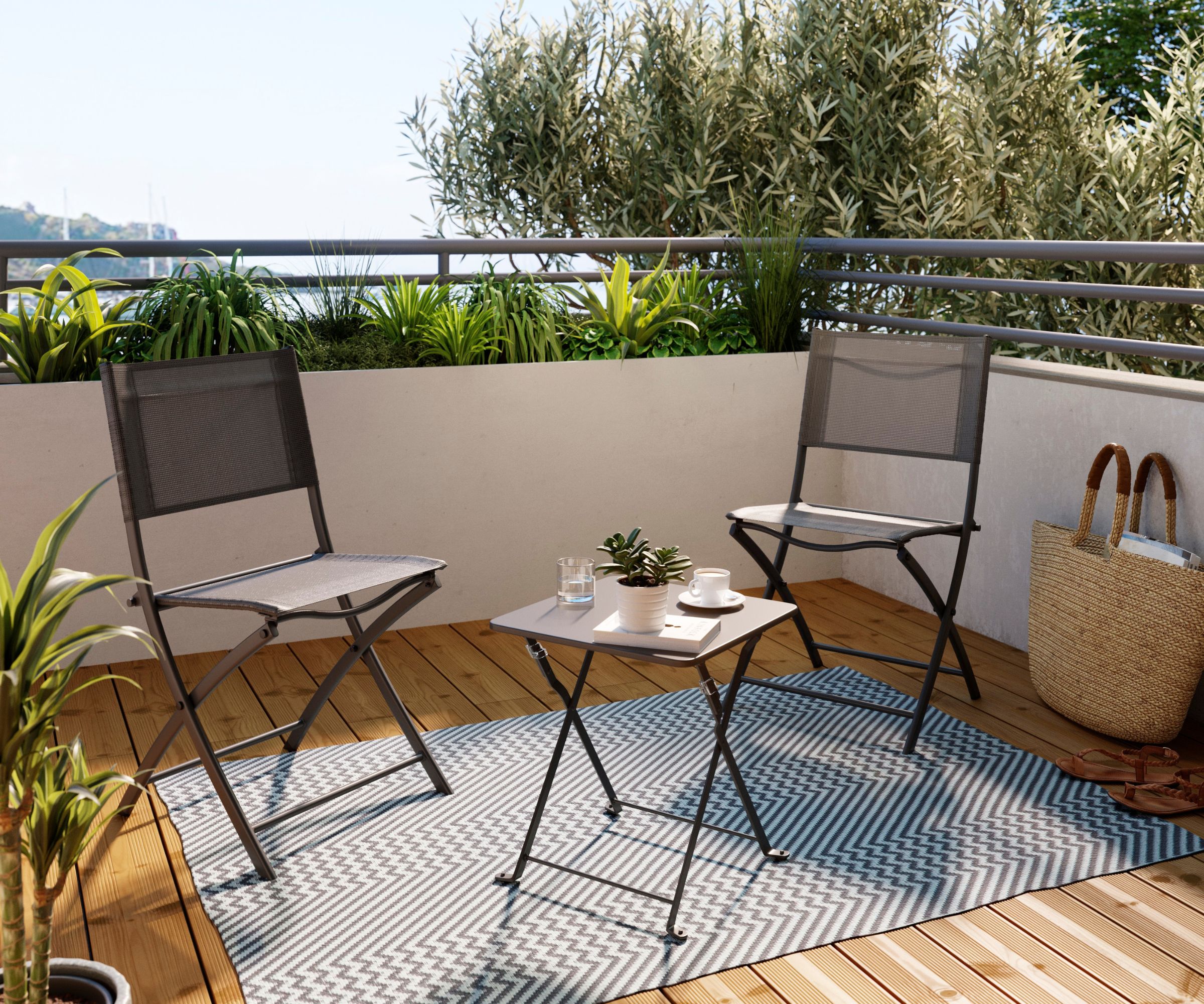 Two folding mesh chairs and small table on wooden balcony, chevron rug, plants, sea view beyond railing.