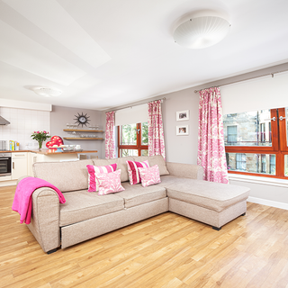 living area with wooden flooring and sofa set with cushions