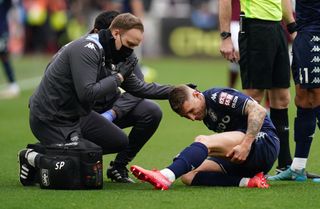 Lucas Digne, right, receives treatment for an injury before leaving the game