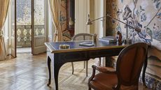 Study with vintage desk, open balcony doors, wooden floors, luxury Raineri Falco wallpaper from Fromental on walls
