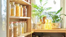 A kitchen with pantry shelves lined with glass jars