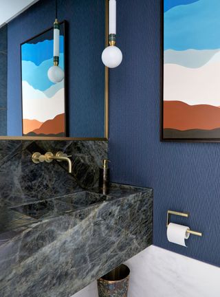 cloakroom with blue textured wallpaper and brass details