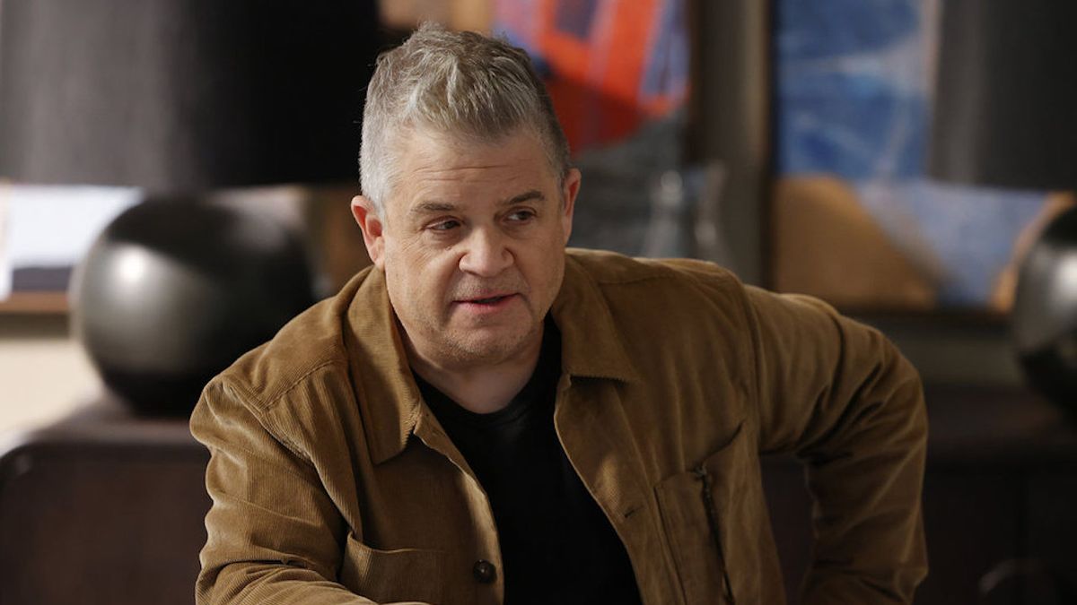 Patton Oswalt wearing brown jacket and black shirt on Suits LA