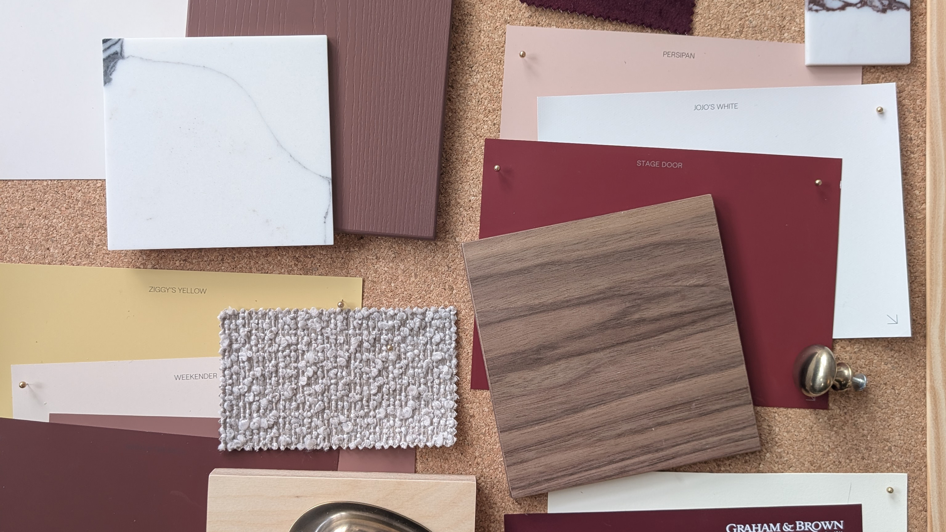 cork board covered in swatches of paint and fabric and wood samples