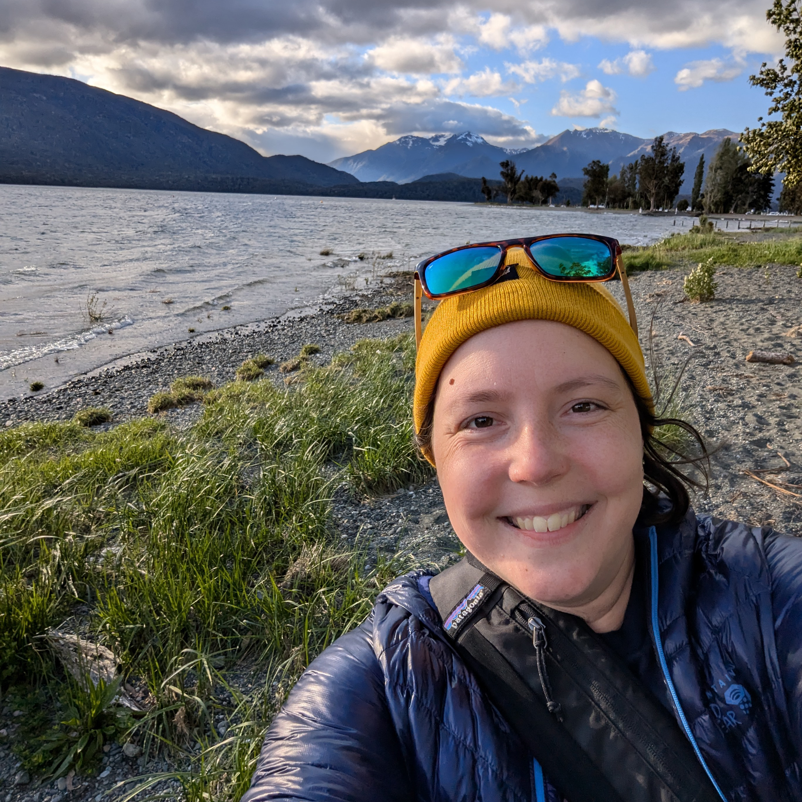 young woman wearing yellow woolly hat with natural landscape. in the background