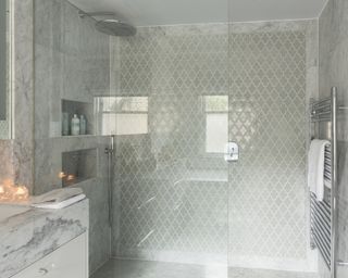 A walk-in shower with both large marble panels and tessellated tiles – Shower tile ideas