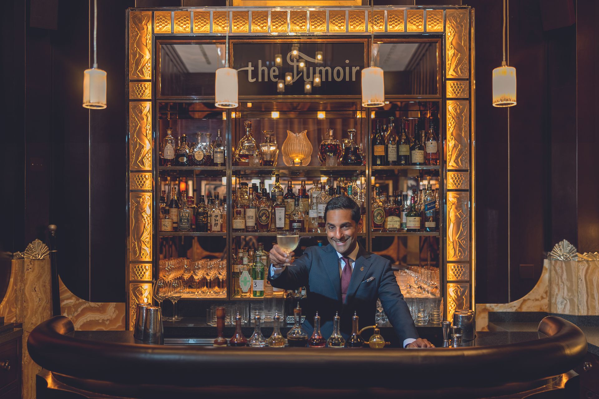 George Raju holds up a wine glass at the Claridge's Bar