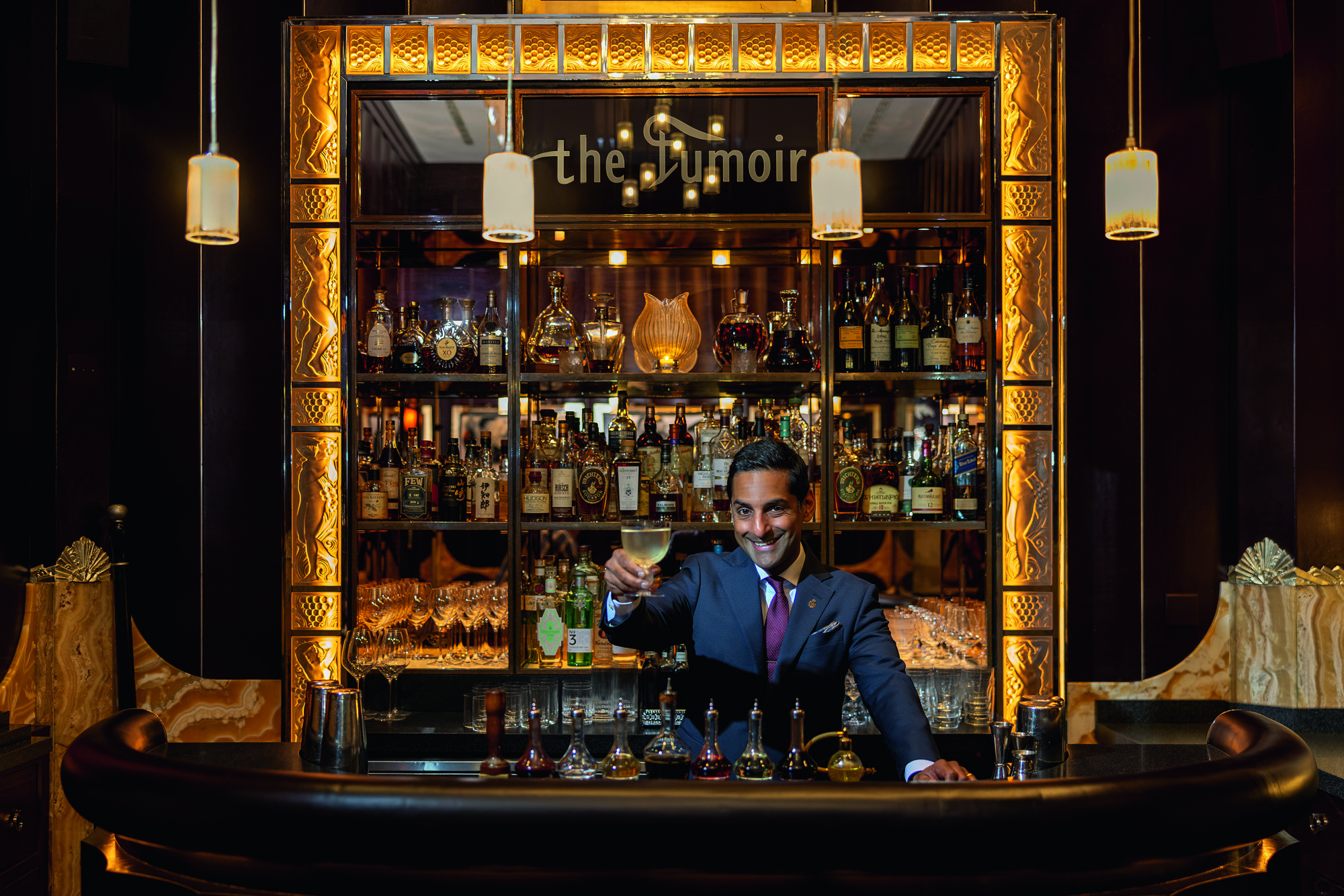 George Raju holds up a wine glass at the Claridge's Bar