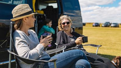 Staycation: People sitting outside campervan