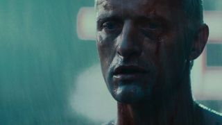 Still from the movie "Blade Runner." Close up of a male android's face who is bleeding from his forehead. His has a sad serene expression. He is drenched as he is standing in the rain.