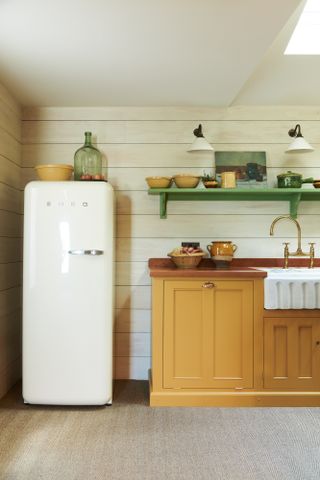 yellow kitchen with Smeg fridge and open shelving by deVOL