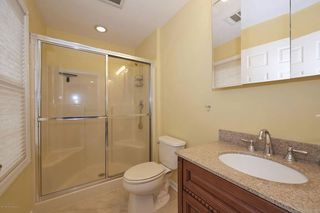 Dated lemon yellow bathroom with walk in shower