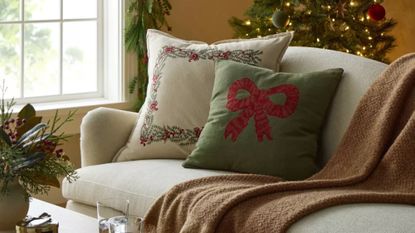 Festive throw pillows and blankets styled in a cozy Christmas living room