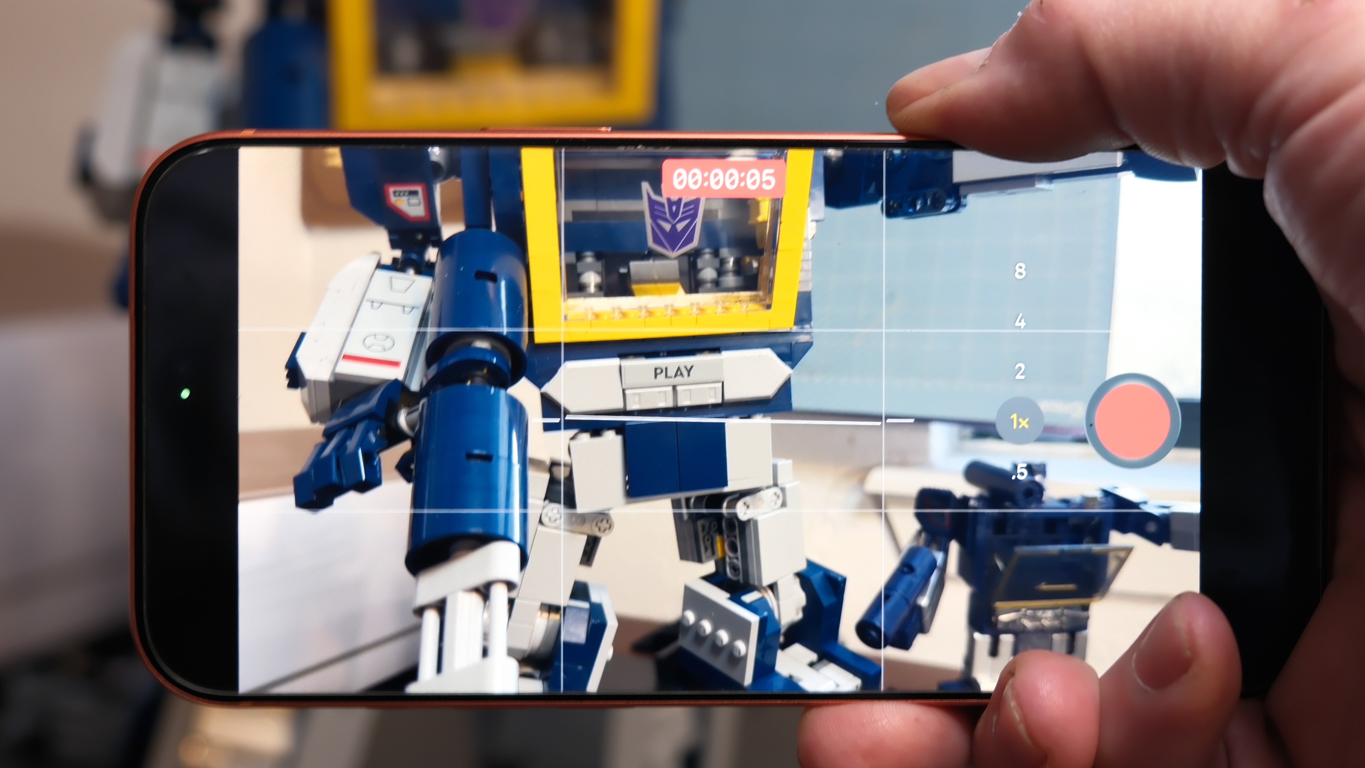 Softwarefuncties van de Camera Control-knop op de Apple iPhone 17 Pro Max in Cosmic Orange, met zoom, camerawisseling, Magnifier-app en meer